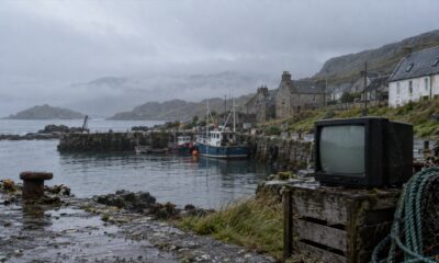 A misty Scottish island harbour with a weathered portable television on the quay.