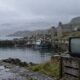 A misty Scottish island harbour with a weathered portable television on the quay.